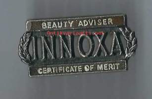 Innoxa   myyjän/tuote-esittelijän merkki metallia, lukkoneulakiinnitys  - rintaneula  rintamerkki