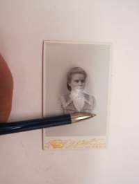 Maria Jalava (Salmikivi) - Atelier Axel Strandberg, Turku -visiittikorttivalokuva -visit card photo, erikoinen koru kaulassa; emaloidut liput ristissä, toisessa