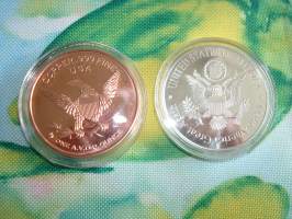 2 kpl erilaisia John F. Kennedy, JFK, mitaleita hienossa rasiassa. 1 av oz (28,35 g) .999 puhdasta kuparia sekä hopeoitu/värillinen mitali. Mitaleiden halkaisija