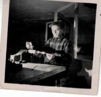 Valokuva 1950-luvulta : Mies  verstaassaan sorvin  äärellä. Koko  6 x 6 cm.