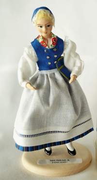 Munsalan puku -  kansallispukunukke - nukke /Käsinmaalattu ja   suomalaiseen kansallispukuun puettu 12 sm korkea nukke, joka onvalmistettu  1990-luvulla