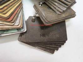 Iwomerite laminaattilevymalleja 1950-luvulta -metalliketjussa olevia 4 x 6 cm paloja, joiden avulla tuotetta myytiin rauta- ym. kaupoissa
