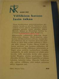 Villikissa katsoo lasin takaa