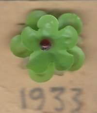 Vappukukka   vappumerkki  1933- neulamerkki  rintamerkki   /   Maitopisarayhdistys Vappukukka on pieni muovinen tai pahvinen rintamerkki, joita myydään