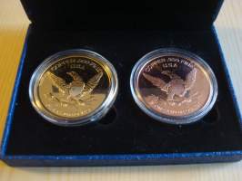 2 John F. Kennedy mitalia, JFK, molemmat 1 av oz (28,35g) puhdasta .999 kuparia, toinen 24k kullattu. Halkaisija noin 38 mm. Muovikotelot ja rasia sisältyy