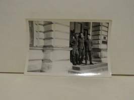 Valokuva kolme sotilasta portailla