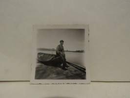 Valokuva sotilas veneen reunalla