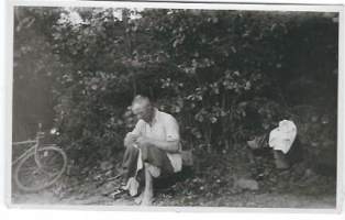Gunnar paikkaa housujaan pyöräretkellä 1940  - valokuva 6x12 cm