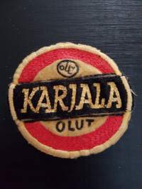Olly Karjala olut - kangas/hihamerkki, Lappeenranta - Lauritsala. 1950-luvulta