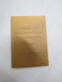 AK - Suomen Autoklubi, muistolaatta Kuljetuspäällikkö Aulis Aarnio, 18.11.1955, laatan suunnitellut John Munsterhjelm, alkuperäisessä kotelossaan