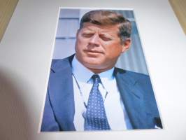 John F. Kennedy valokuva ja nimikirjoitus joka on painettu paksuhkolle ja matalle valokuvapaperille. Paspiksen koko A4 eli helppo kehystää.