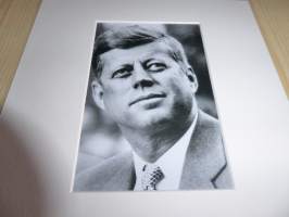 John F. Kennedy valokuva ja nimikirjoitus joka on painettu paksuhkolle ja matalle valokuvapaperille. Paspiksen koko A4 eli helppo kehystää.