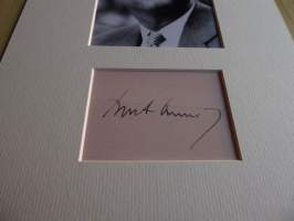 John F. Kennedy valokuva ja nimikirjoitus joka on painettu paksuhkolle ja matalle valokuvapaperille. Paspiksen koko A4 eli helppo kehystää.