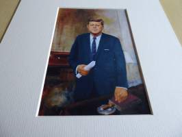 John F. Kennedy valokuva ja nimikirjoitus joka on painettu paksuhkolle ja matalle valokuvapaperille. Paspiksen koko A4 eli helppo kehystää.