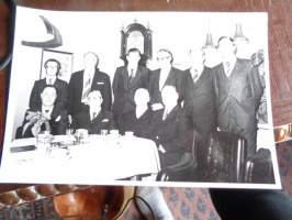 Valokuva Ryhmäkuva miehiä pöydän takana