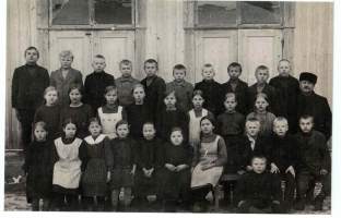 Valokuva. oppilaita kuvattavana koulun  ulkopuolella 1930-luvulla