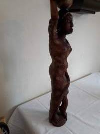 Pienoispatsas. Etelä-amerikkalainen ylväästi taakkaansa kantava neito  Tukeva puinen käsityö.Korkeus 52 cm. leveys, rinnankorkeudelta 11cm, jalusta 10 cm