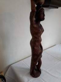 Pienoispatsas. Etelä-amerikkalainen ylväästi taakkaansa kantava neito  Tukeva puinen käsityö.Korkeus 52 cm. leveys, rinnankorkeudelta 11cm, jalusta 10 cm