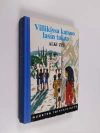 Villikissa katsoo lasin takaa