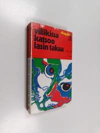 Villikissa katsoo lasin takaa