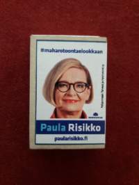 Tulitikku aski.  Paula Risikon vaalimainos kylkiäinen .  Ilmeisesti Pohjanmaan hyvinvointi yhteiskuntaan. Tikuista puolet jäljellä