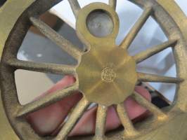 VR 100 vuotta 1962 -lipputanko, ilmeisesti VR:n jollain omalla valimolla / konepajalla valmistettu juhlatanko, jossa tyylitelty veturin "pyörä", messinkiä