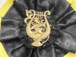 Merkantila klubben Åbo Akademi -erä sen toimintaan liittyviä yhden henkilön merkkejä; Ruusuke, kaulariipus, neulamerkit, mitali, kangasmerkit, tarra -osa hopeaa