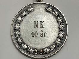 Merkantila klubben Åbo Akademi -erä sen toimintaan liittyviä yhden henkilön merkkejä; Ruusuke, kaulariipus, neulamerkit, mitali, kangasmerkit, tarra -osa hopeaa