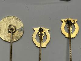 Merkantila klubben Åbo Akademi -erä sen toimintaan liittyviä yhden henkilön merkkejä; Ruusuke, kaulariipus, neulamerkit, mitali, kangasmerkit, tarra -osa hopeaa