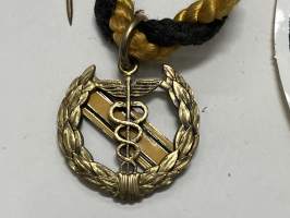 Merkantila klubben Åbo Akademi -erä sen toimintaan liittyviä yhden henkilön merkkejä; Ruusuke, kaulariipus, neulamerkit, mitali, kangasmerkit, tarra -osa hopeaa