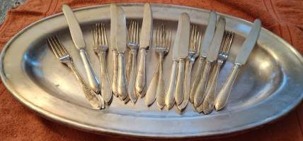 Ruokailuväline sarja alpakkaa (uushopea)Tusina lusikoita,, haarukoita,veitsistä puuttuu yksi. Mukana myöskin upea vati paistille  vihannesvalikoimalle, leikkeille