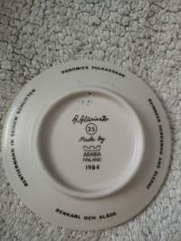 Arabia, A. Alariesto : poromies pulkassaan 25, seinälautanen v. 1984