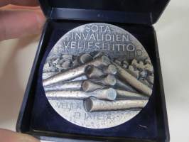 Sotainvalidien Veljesliitto 1939-1945 Krisgsinvalidernas Brödraförbund -mitali, suunnitellut Heikki Häiväoja, hopeasävyinen, numeroitu 0136 / 2000