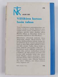 Villikissa katsoo lasin takaa